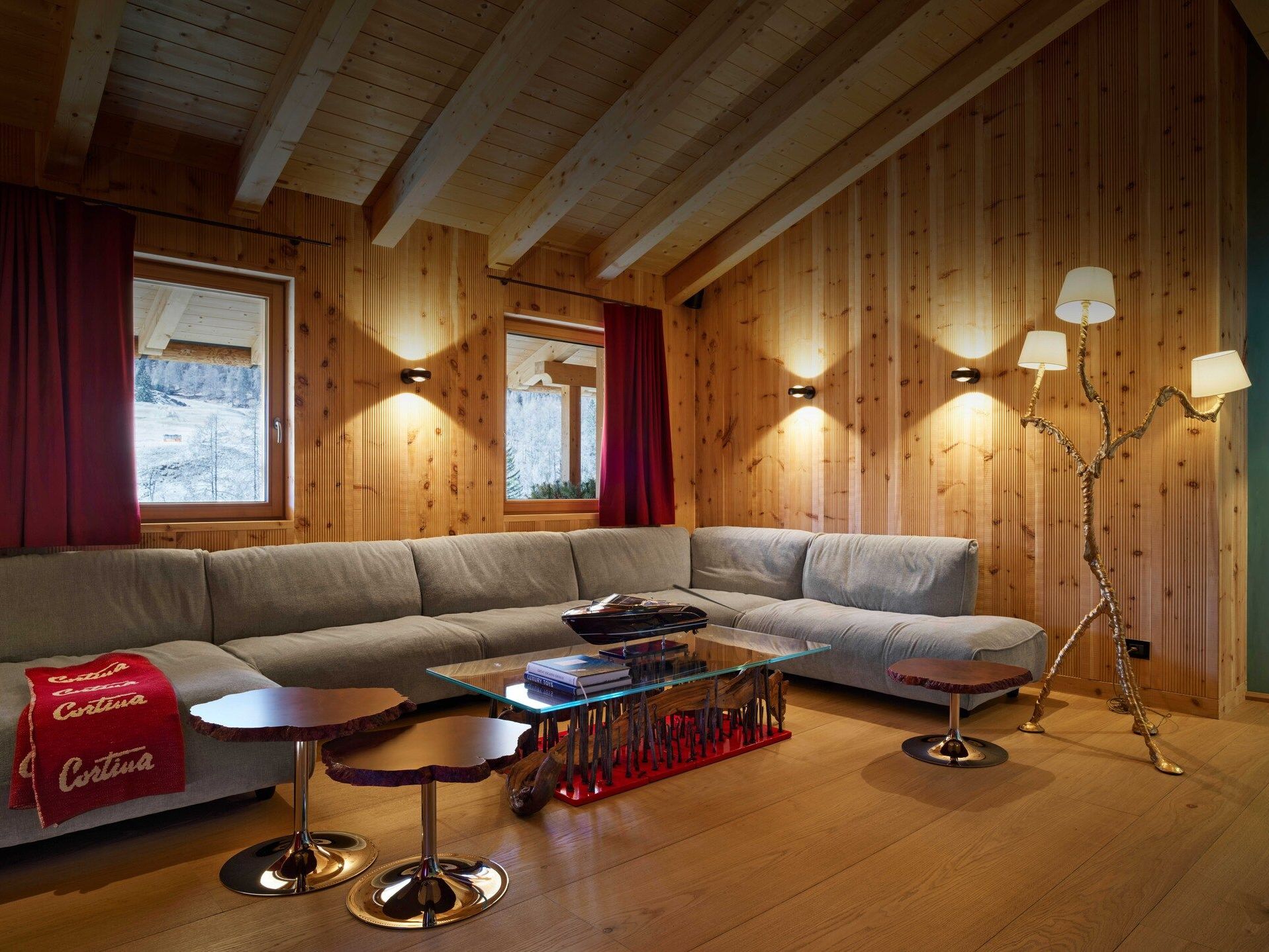 Grande Soffice and Cicladi . The sofa by Francesco Binfaré in angular composition inside the living room of the chalet serge together with the tables and the Jacopo Foggini lamp.