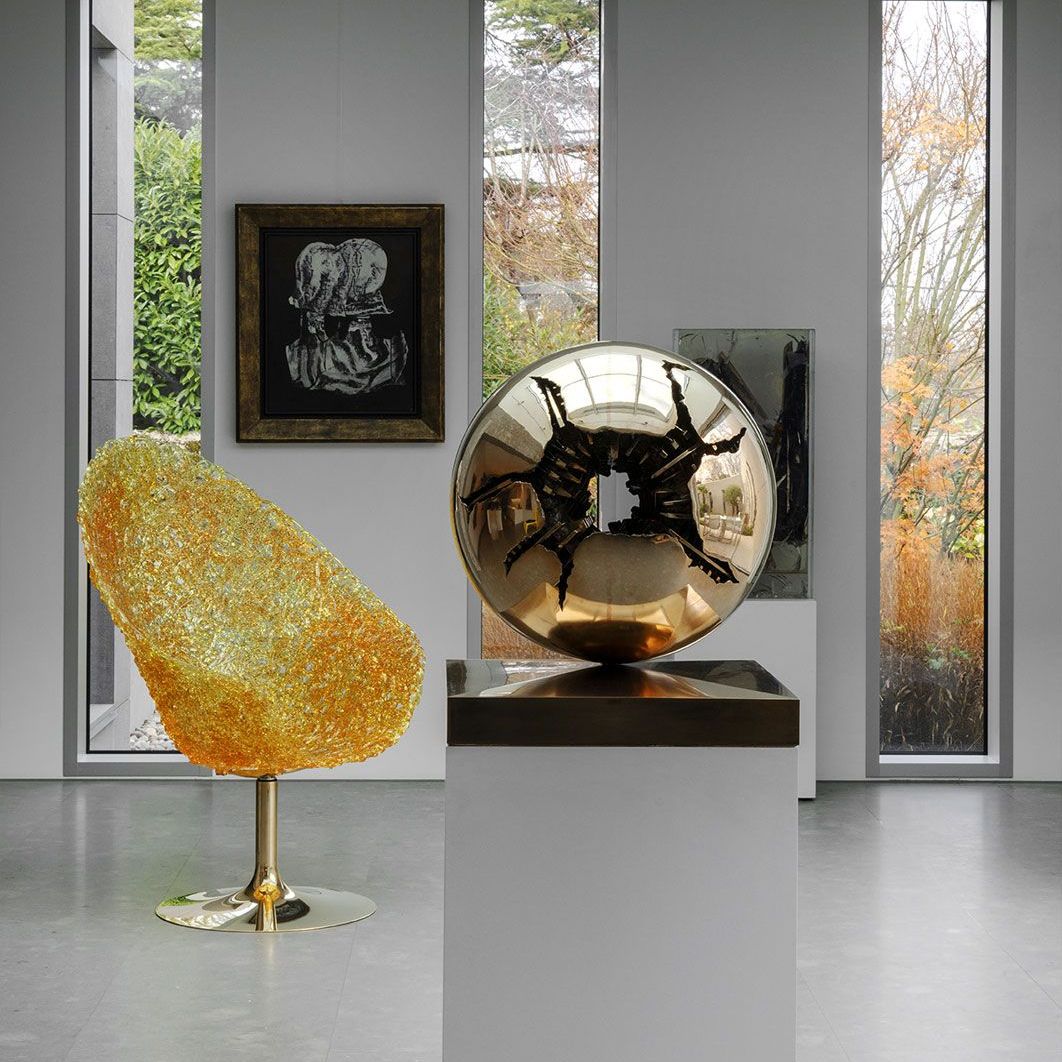   Margherita . the polycarbonate armchair next to a sculpture by Arnaldo Pomodoro 