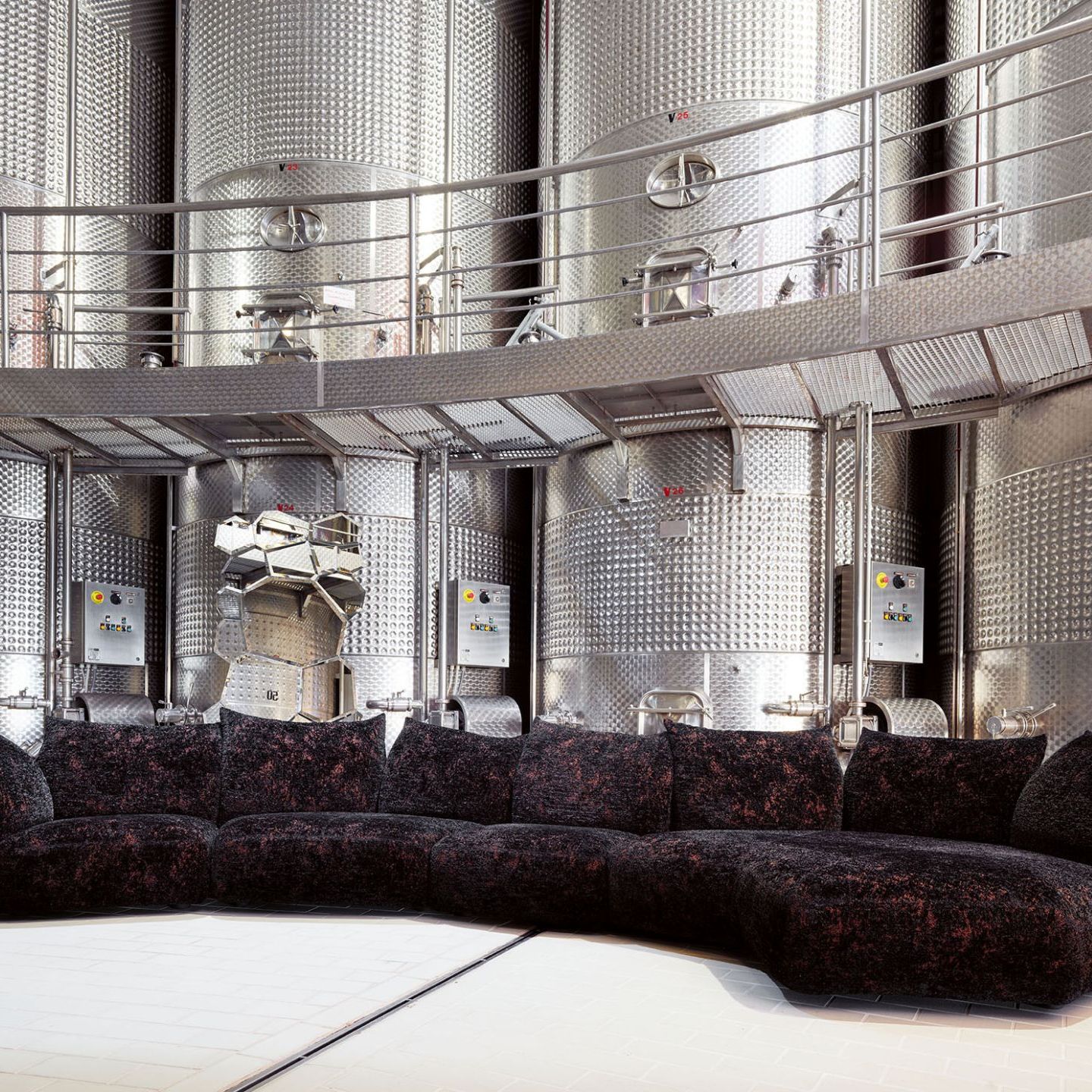  Standard. Previous page, a composition of the sofa upholstered in Jin Gems Jasper, a deep black with glints of metall, accentuates the circular arrangement and sheen of the huge steel silos. 