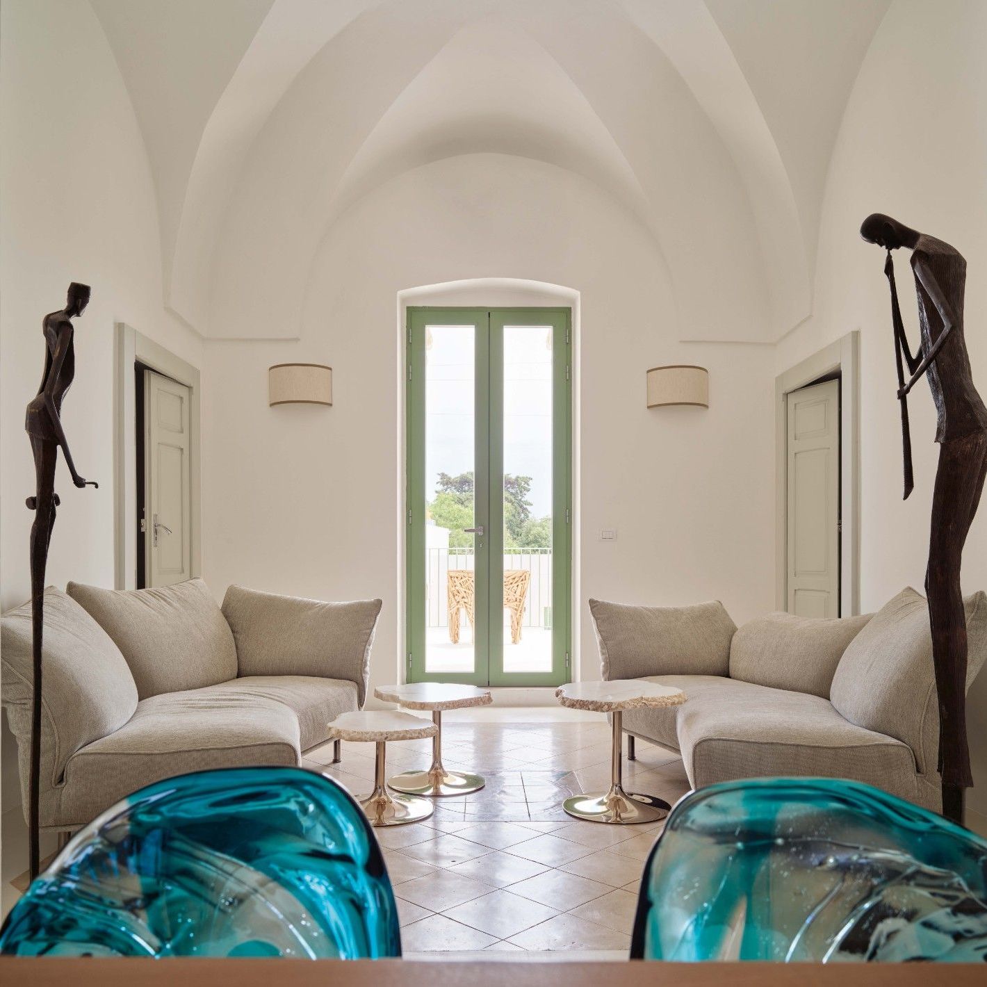  Standalto, Cicladi. Im Wohnzimmer greifen die weichen Formen der Sofas aus Soft Imperial und der Tische aus Alabaster die Kurven der Fassadentreppe auf. 