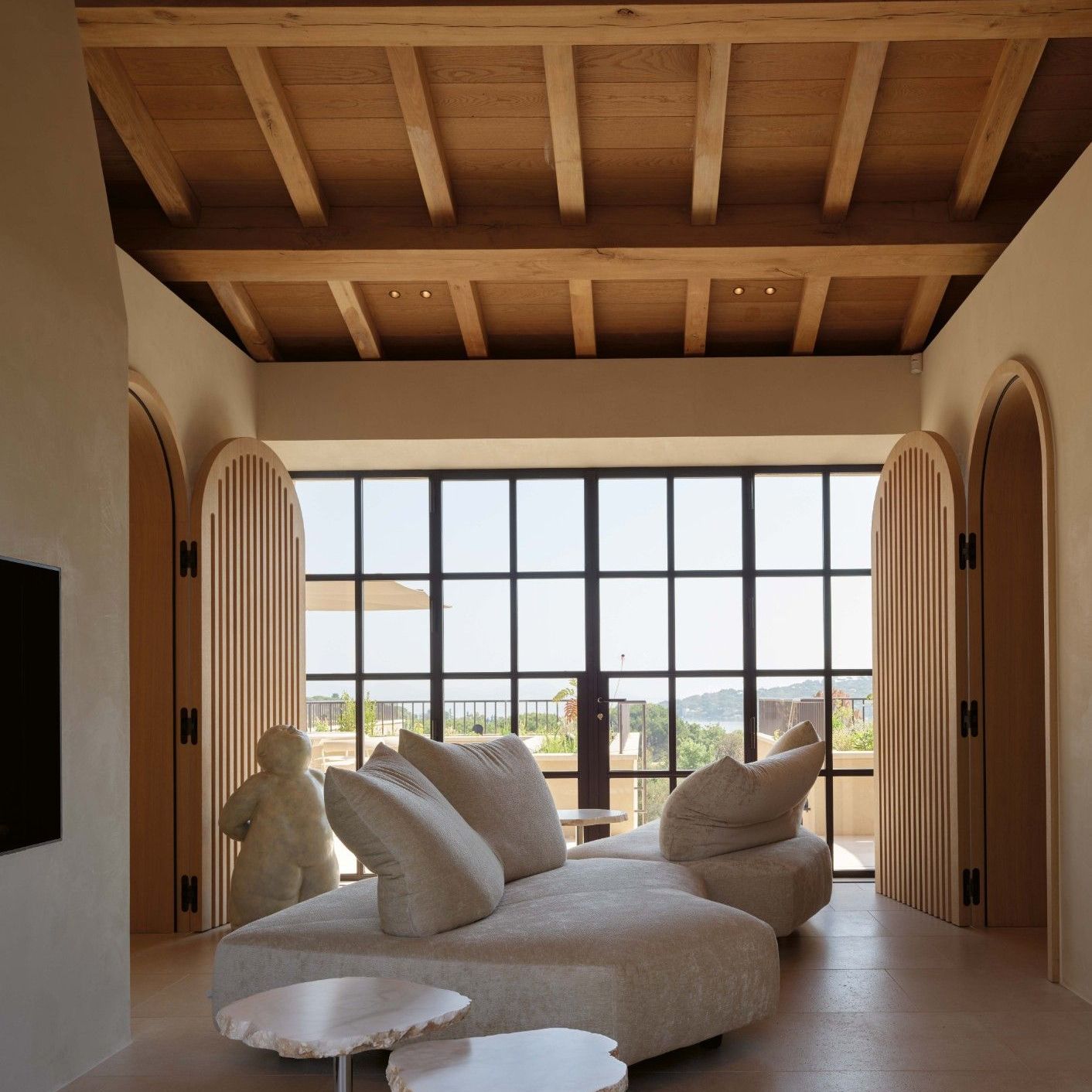  Anywhere, Cicladi. The sofa in Gentle Cloud and tables in natural alabaster organise a living room open on both sides. 