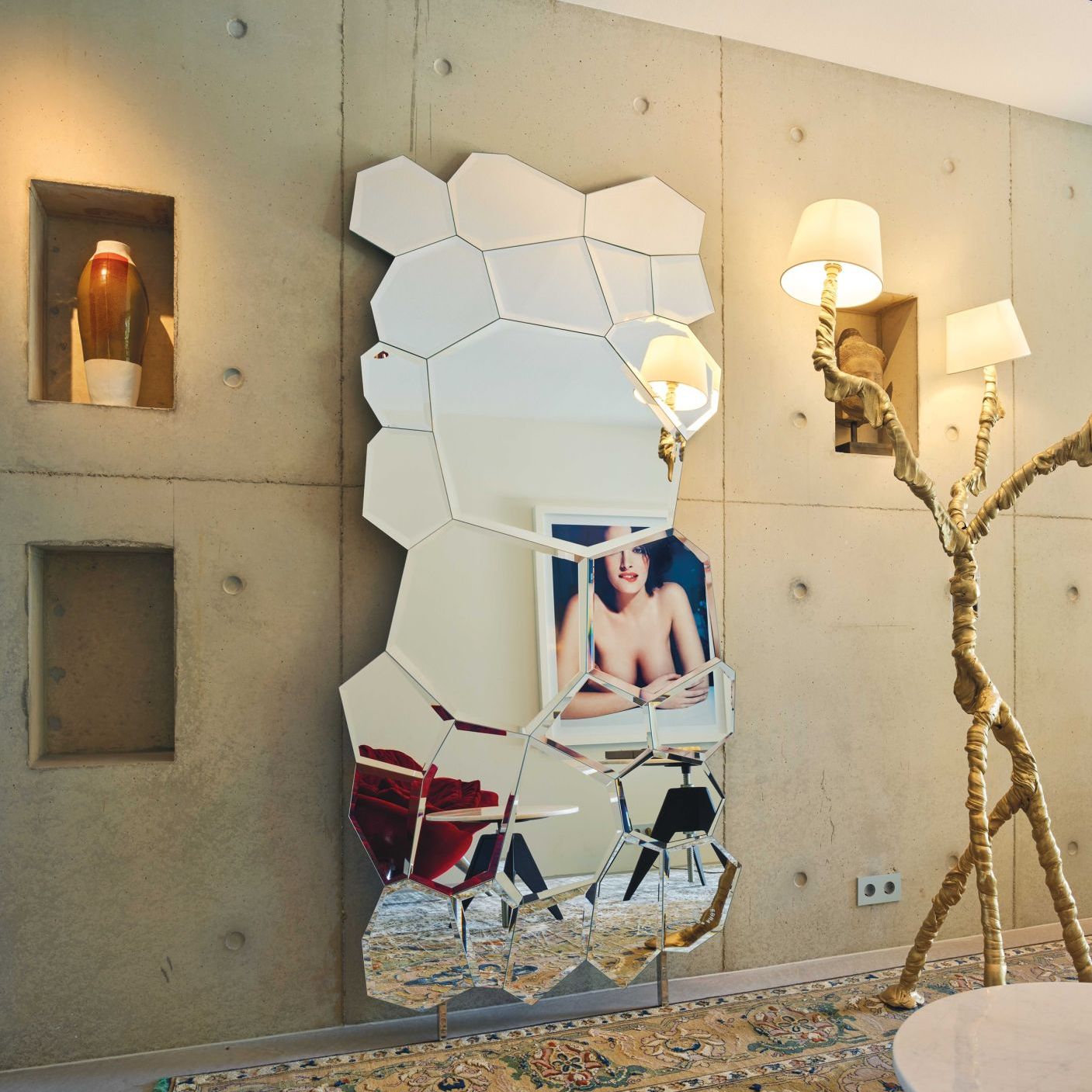   Jubilé.  In a contrast with concrete the mirror’s 25 shapes reflect light, artworks and furnishings. 