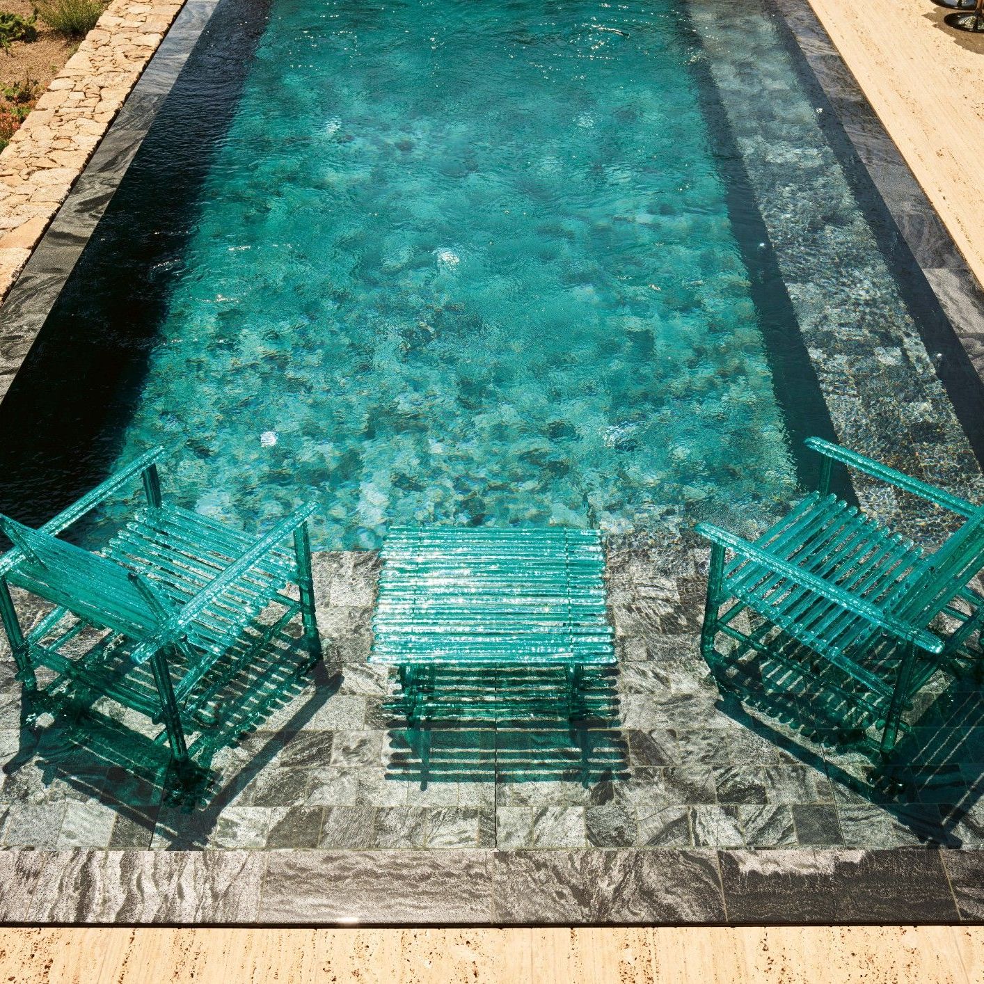  Sunbeds, tables and armchairs from the outdoor collection reflect the sunlight and colours of the pool. 