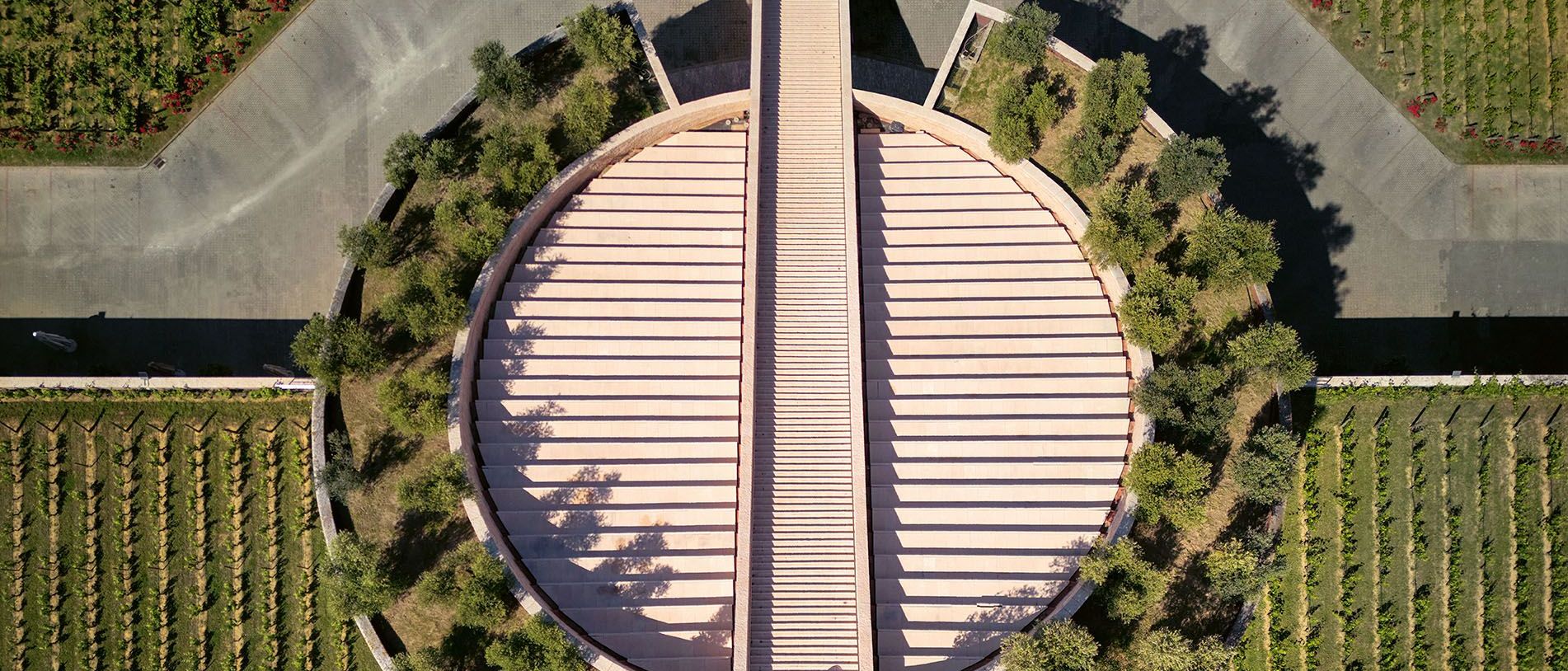 Petra Winery. The sloping roof of the sectioned cylinder is dotted with hanging gardens and a scenic staircase creates a groove down the axis. 