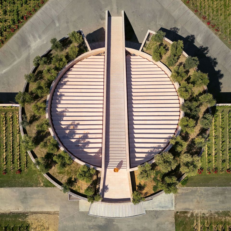  Petra Winery. The sloping roof of the sectioned cylinder is dotted with hanging gardens and a scenic staircase creates a groove down the axis. 